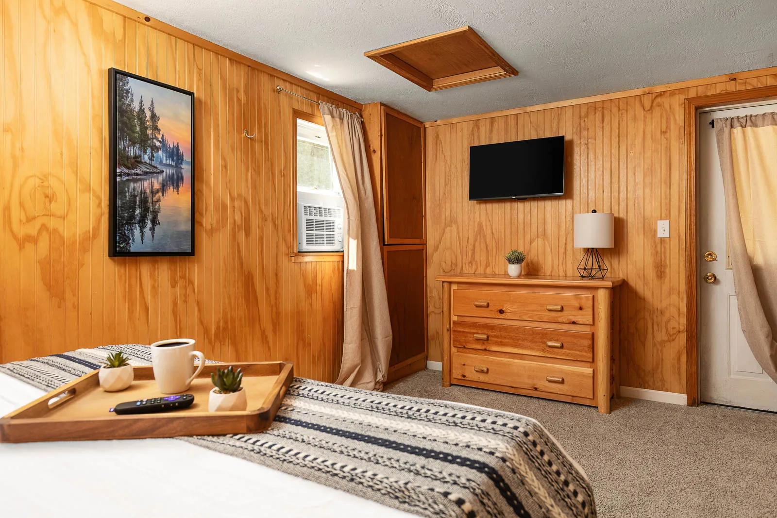Full bedroom with TV and dresser inside The House