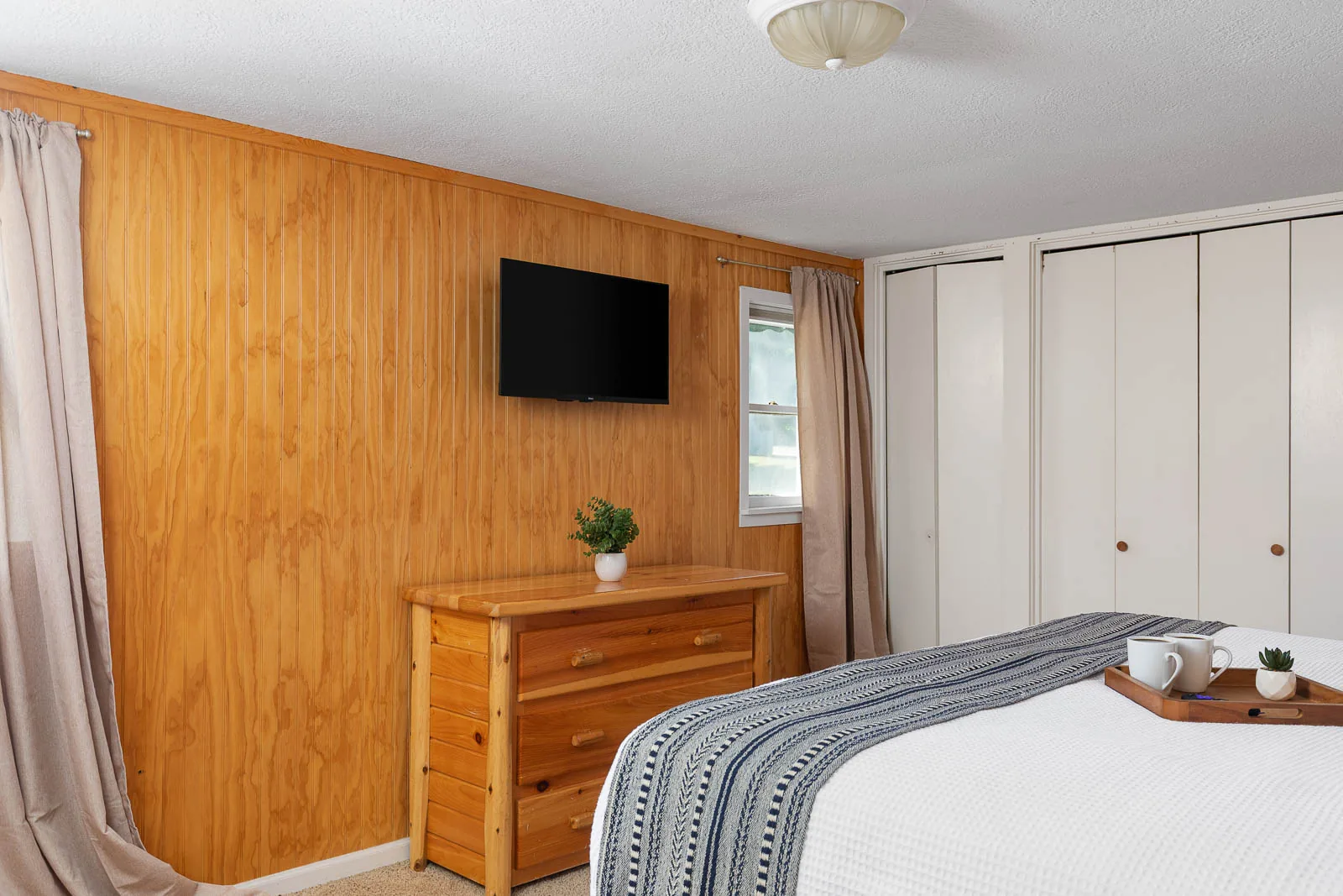 King bedroom with TV and storage inside The House