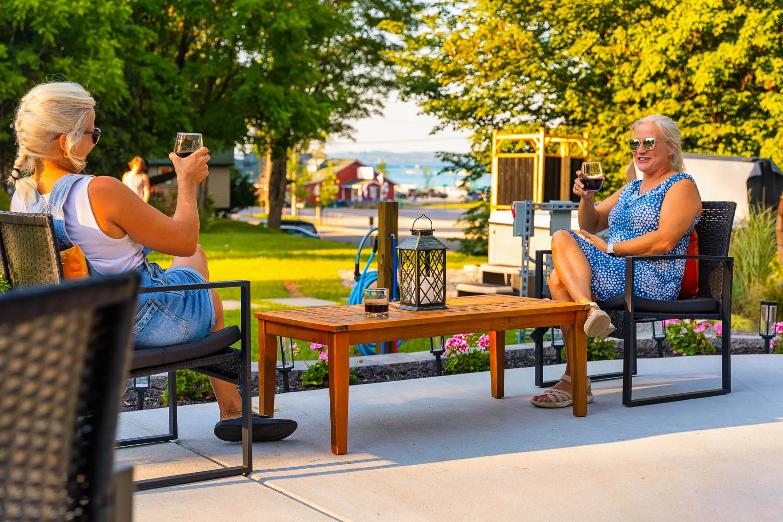 Guests relaxing with wine near the pavilion and lake view