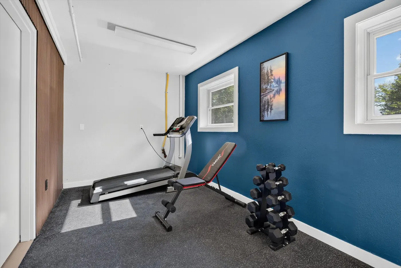 Fitness room with treadmill, bench, and free weights