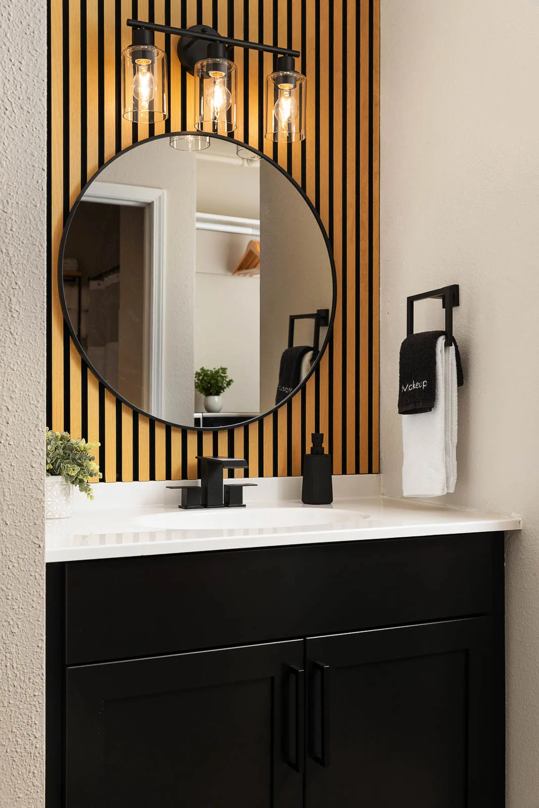 Two Queens Lodge Suite bathroom vanity with round mirror